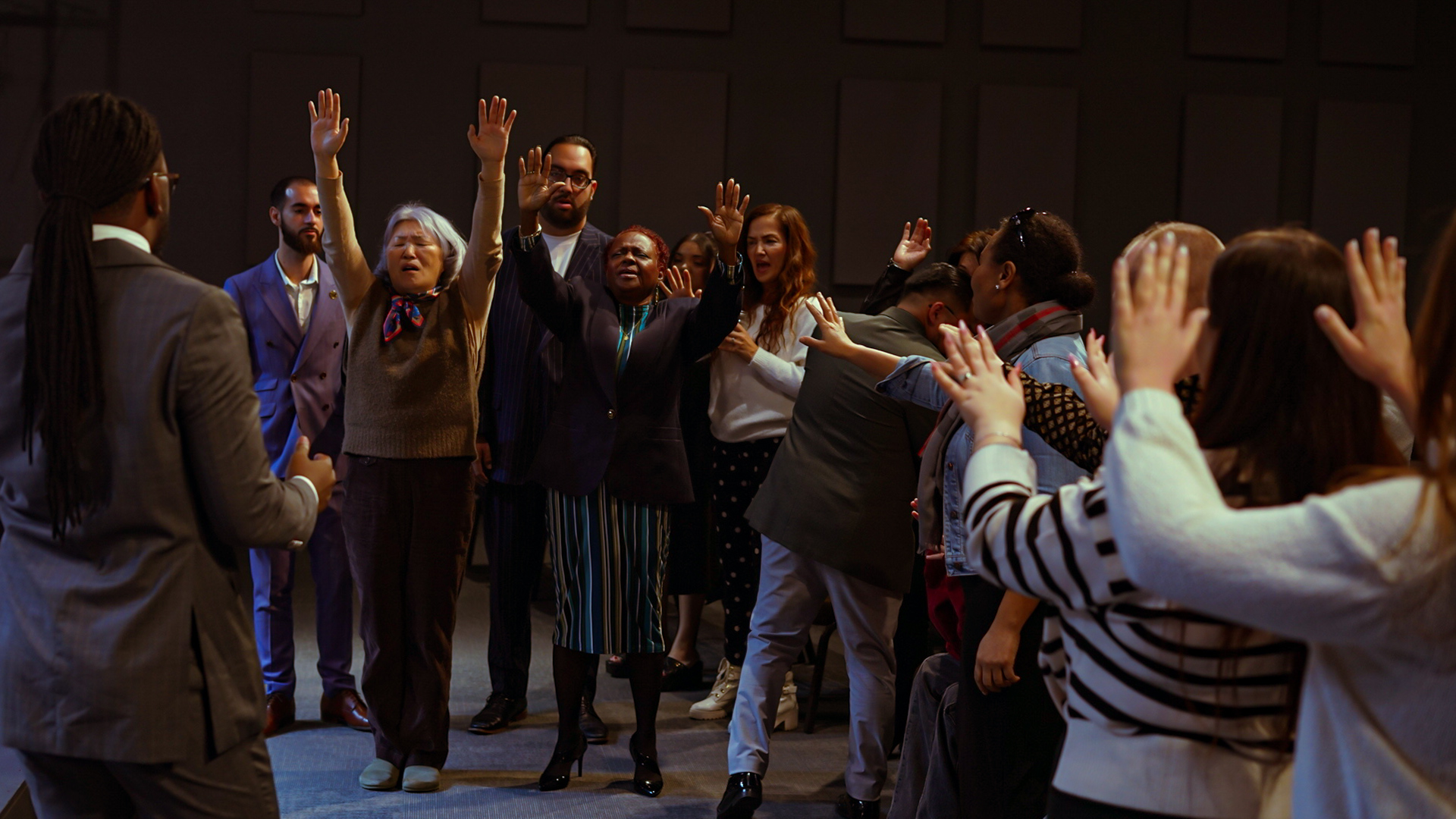 Rebirth Nation church family gathered in worship and prayer with raised hands